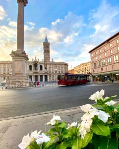 羅馬的住宿－B&B Smart，一辆红色的公共汽车驶过城市的纪念碑