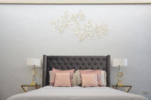 una camera da letto con un grande letto con cuscini rosa di Campana Suites a Bibbiena