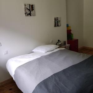 - une chambre avec un grand lit et des draps blancs dans l'établissement Les Lodges Du Pavillon F3, à Molinges