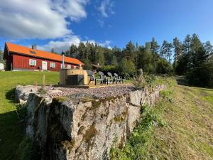 a stone retaining wall with chairs and a building at Projekt Schwedenalm in Furudal