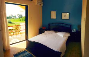 a bedroom with a bed and a view of a balcony at Aenaon Studios in Oreoí
