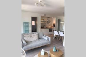 a living room with a couch and a kitchen at Cosyinlaboe in Laboe