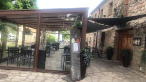 un ristorante con patio arredato con tavoli e sedie di Hostal Bavieca a Medinaceli