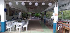 a restaurant with white tables and white chairs at Laureana Hotel Campestre in Agua de Dios