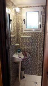 a bathroom with a sink and a window and a mirror at La Cabaña in Tandil