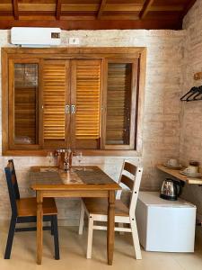 a wooden table and chairs in a kitchen at Refúgio Physis Suítes in Monte Verde