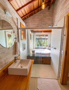 a large bathroom with a sink and a tub at Refúgio Physis Suítes in Monte Verde