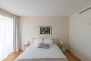 a bedroom with a large white bed with white pillows at thecamp hôtel Eco Lodge- Aix en Provence in Aix-en-Provence