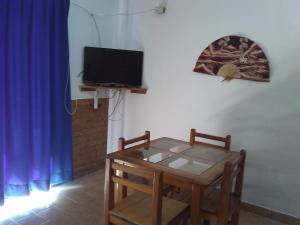 Zimmer mit einem Tisch und einem TV sowie einem Tisch und Stühlen in der Unterkunft Olas Altas 534 Interior 4 in Puerto Vallarta