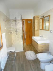 "Casa Elda" 110 mq primo Piano a Coredo TRENTO في كوريدو: حمام مع حوض ودش ومرحاض +26 صورة