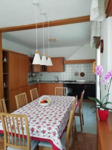 "Casa Elda" 110 mq primo Piano a Coredo TRENTO في كوريدو: مطبخ وغرفة طعام مع طاولة وكراسي