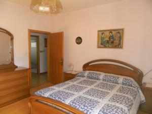 "Casa Elda" 110 mq primo Piano a Coredo TRENTO في كوريدو: غرفة نوم بسرير وصورة على الحائط