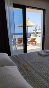 Villa Primo Opus في كساميل: غرفة نوم بسرير وإطلالة على الشاطئ
