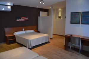 a hotel room with two beds and a desk and a desk at Marina Tossa in Tossa de Mar
