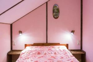 a bedroom with a bed with a pink wall at Tomi Lägenheter in Stockholm
