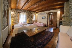 a bedroom with a bed and a table and a couch at Arhontiko Aristis in Aristi