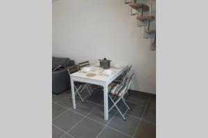 einen weißen Tisch mit Stühlen in einem Zimmer in der Unterkunft Maison de pêcheur près du port in Étaples