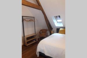 a bedroom with a white bed and a chair at Maison de pêcheur près du port in Étaples