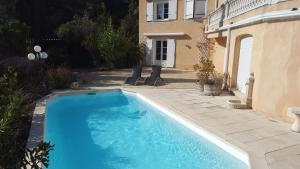 uma grande piscina azul ao lado de um edifício em Mas des Marcellines em La Bouilladisse