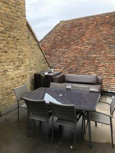 a patio with a table and chairs and a couch at The Old Bakery in Sandwich
