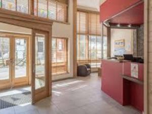 a large kitchen with red cabinets and windows at Appartement La Tania, 2 pièces, 5 personnes - FR-1-513-78 in La Tania