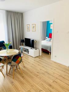 ein Wohnzimmer mit einem Tisch und ein Schlafzimmer in der Unterkunft Apartament Walczaka nr 16 MIEJSCE PARKINGOWE in Gorzów Wielkopolski