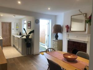 a kitchen and dining room with a table and a fireplace at Boutique City Centre Home in Chichester