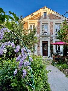 een huis met paarse bloemen ervoor bij Maison du bonheur in Villiers-sur-Marne