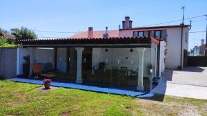 a house with a glassconservatory in a yard at Casa rural A Santiaga en Costa da Morte in Cabana de Bergantiños