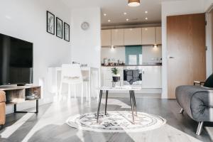 uma sala de estar com um sofá e uma mesa em Oakgrove Apartment - 2 Bedroom with Terrance and private parking em Milton Keynes