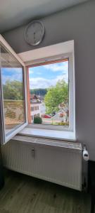a window with a clock on the wall and a radiator at Pension-Maulburg in Maulburg