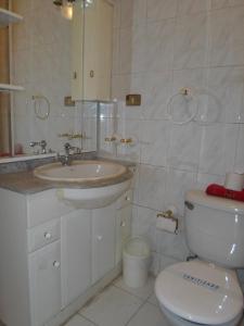 a white bathroom with a sink and a toilet at Hostal Fx in Puerto Montt