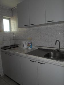 a kitchen with a sink and a counter top at Apart Hotel Fx in Puerto Montt