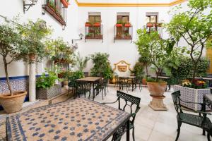 un patio extérieur avec des tables, des chaises et des arbres dans l'établissement Eurostars Maimonides, à Cordoue