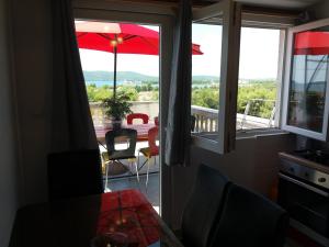 a view of a balcony with a table and an umbrella at Apartman Lea in Brodarica +73 photos
