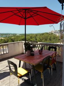 a wooden table with chairs and an umbrella on a roof at Apartman Lea in Brodarica