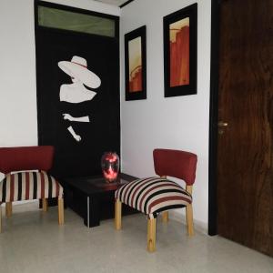 Pokój z 2 krzesłami, stołem i zdjęciem w obiekcie Rosa Ramona Rooms w mieście San Salvador de Jujuy