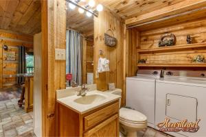 La salle de bains est pourvue de toilettes et d'un lavabo dans une cabane en rondins. dans l'établissement Cozy Mountain Hideaway, à Gatlinburg