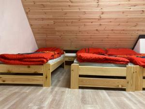 two twin beds in a room with wooden walls at Chata v Beskydech Trojanovice in Trojanovice