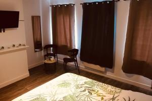 a bedroom with two chairs and a bed and a window at Le Wild Abbeville centre ville baie de Somme in Abbeville