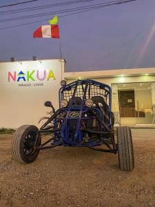 un véhicule bleu à quatre roues garé devant un bâtiment dans l'établissement Nakua Paracas Lodge, à Paracas