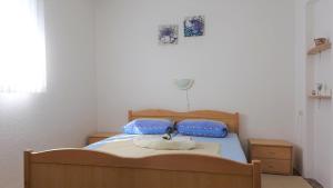 a bedroom with a bed with two blue pillows at 35 meters from sea Sweat house with garden in Karlobag