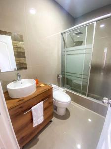 a bathroom with a sink and a toilet and a shower at Nakua Paracas Lodge in Paracas