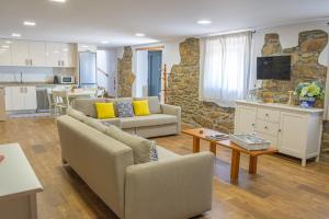 a living room with two couches and a kitchen at Refúgio Da Gandra in Vila Nova de Cerveira