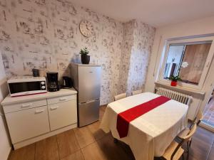 a small kitchen with a table and a refrigerator at Workershome - Business Apartments - Monteurwohnungen in Wertheim +20 photos