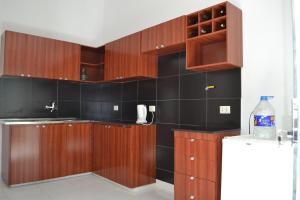 una cocina con armarios de madera y azulejos negros en La Banda Apart Hotel, en Tarija