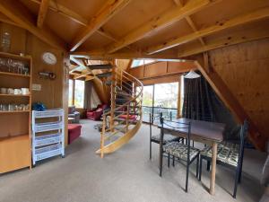 a living room with a spiral staircase in a house at 9 Chalet Cres in Hanmer Springs