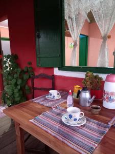 a wooden table with two cups and saucers on it at Chalés Encantos de Cunha Vermelho in Cunha