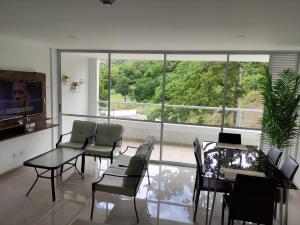 sala de estar con mesa, sillas y ventana grande en Casitadisol, en Santa Fe de Antioquia