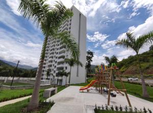 un edificio con parque infantil junto a una palmera en Casitadisol, en Santa Fe de Antioquia